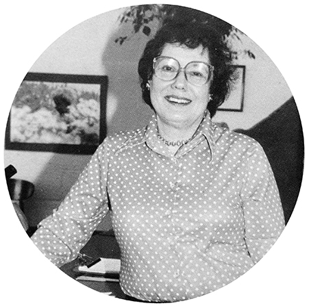 Black and white photograph of Principal Kay Steiert from Great Falls Elementary School’s 1981 to 1982 yearbook. She is wearing a polka dot blouse and is standing in school office.