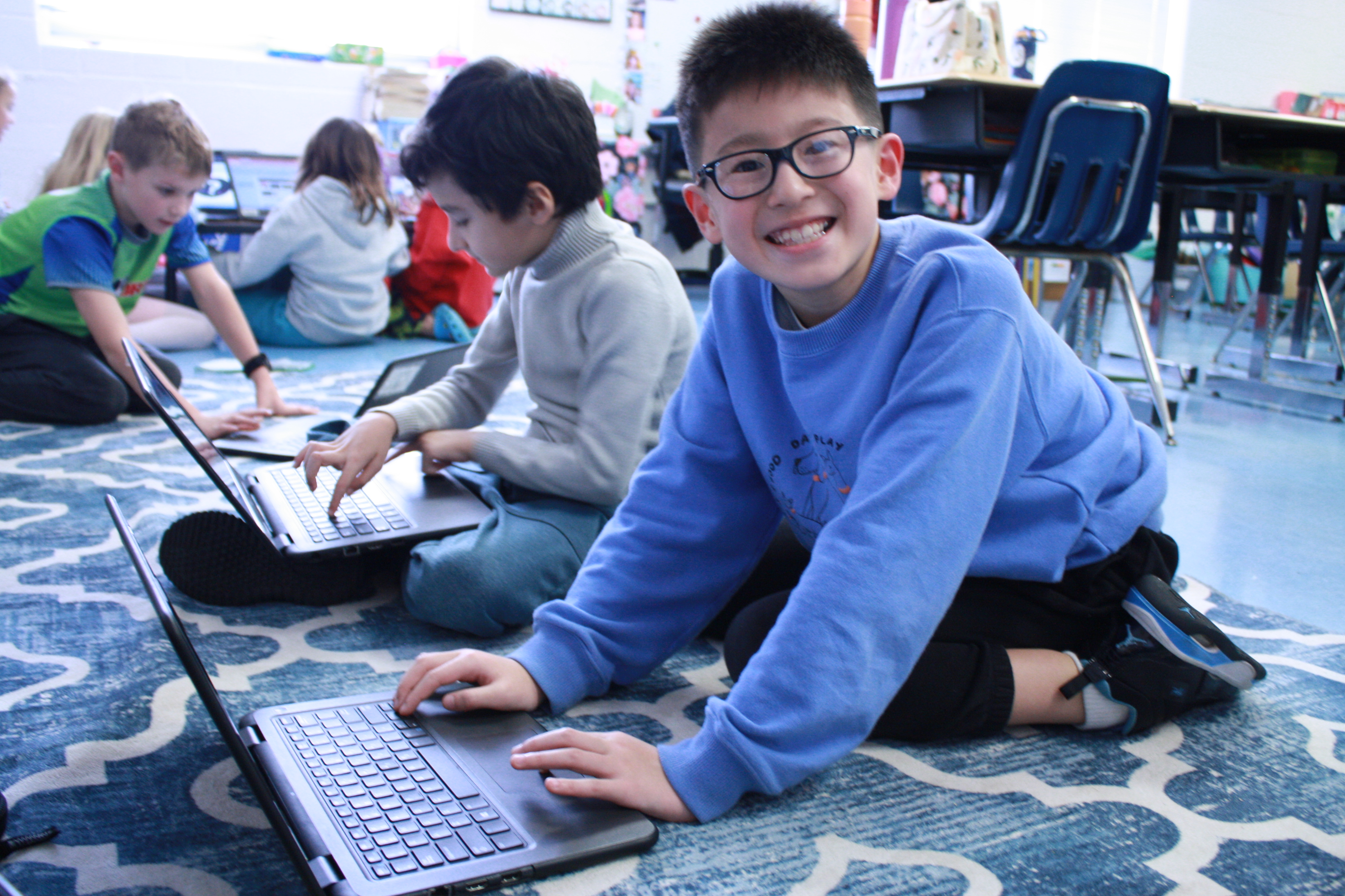 3rd grade boys work on laptops