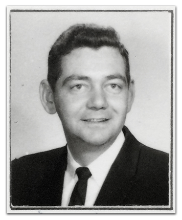 Black and white, head-and-shoulders staff portrait of Principal Meadows taken during the 1962 to 1963 school year. He is wearing a white shirt and a dark tie and jacket.