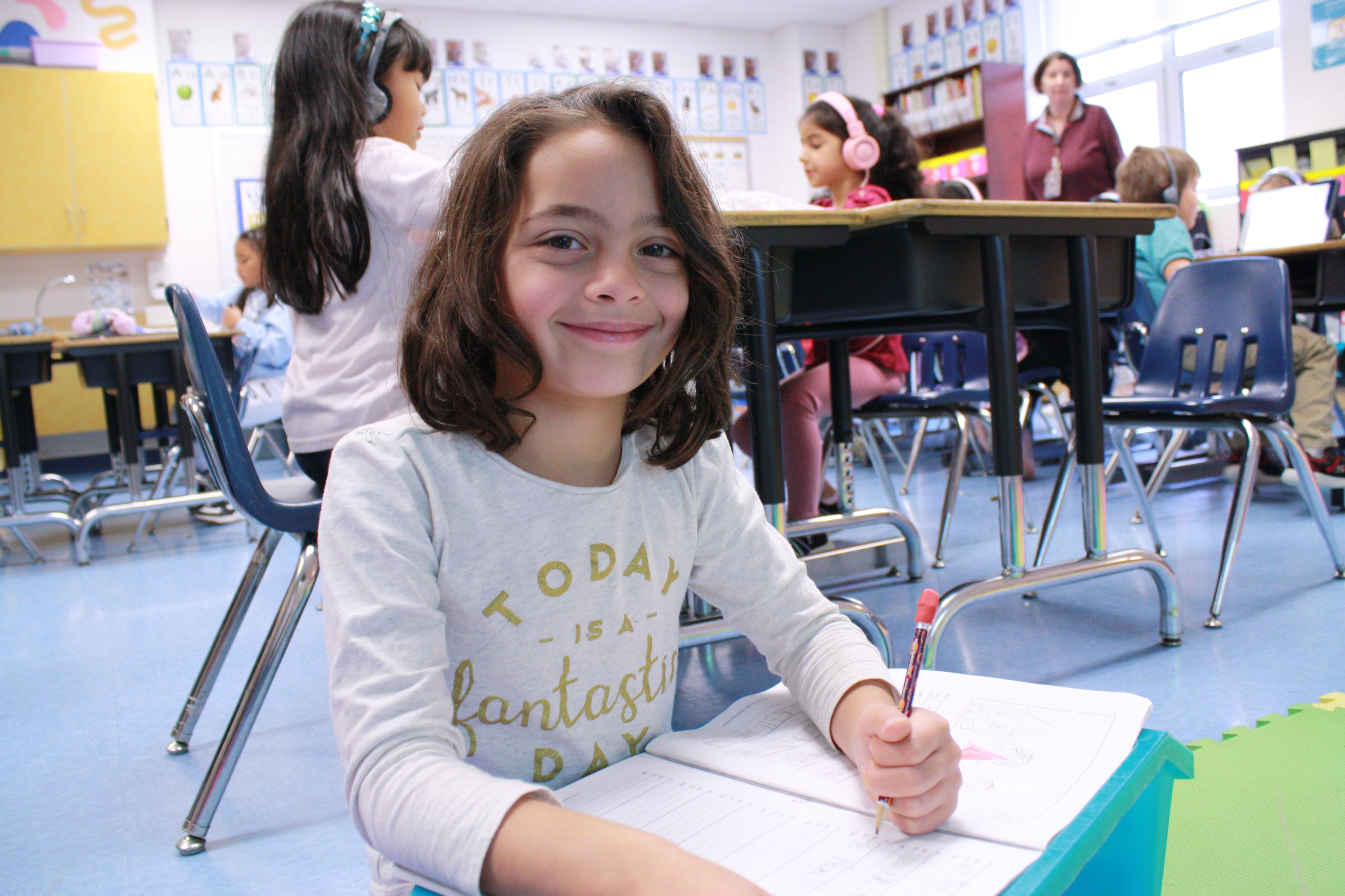 A 1st grade girl works in her notebook