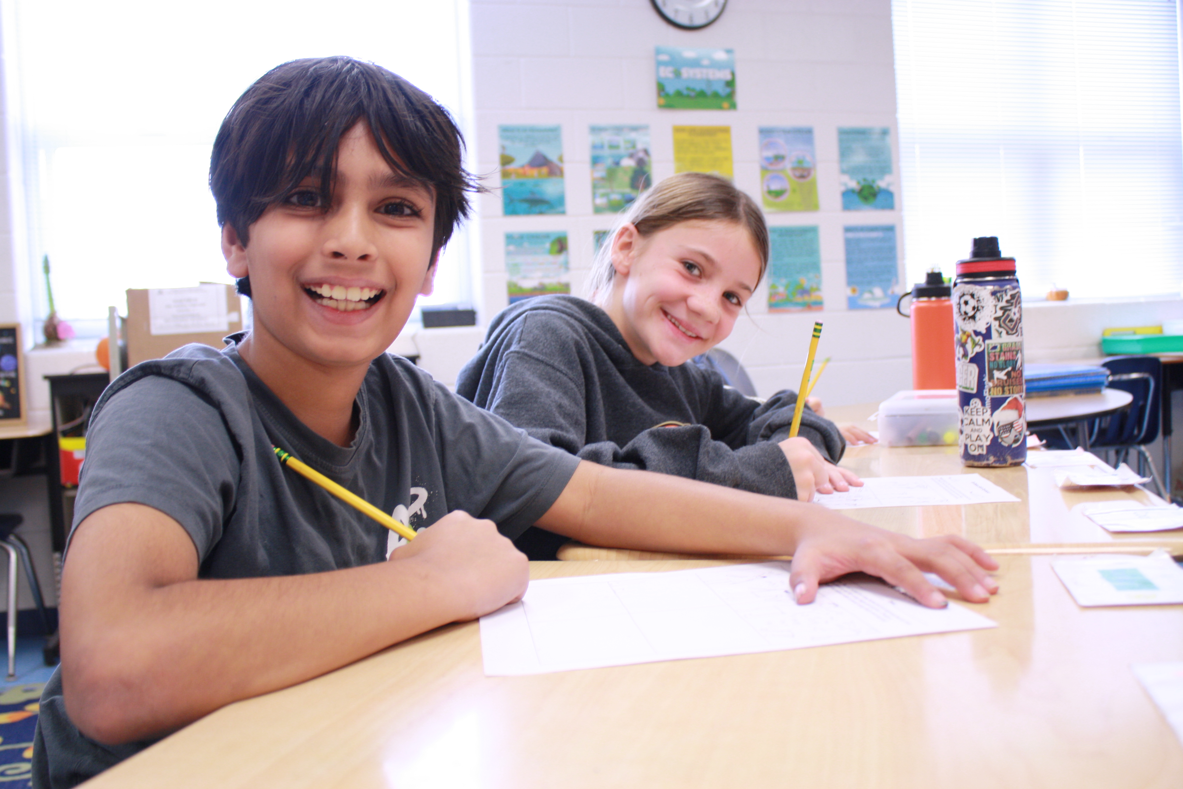 Two 4th graders work at their desks