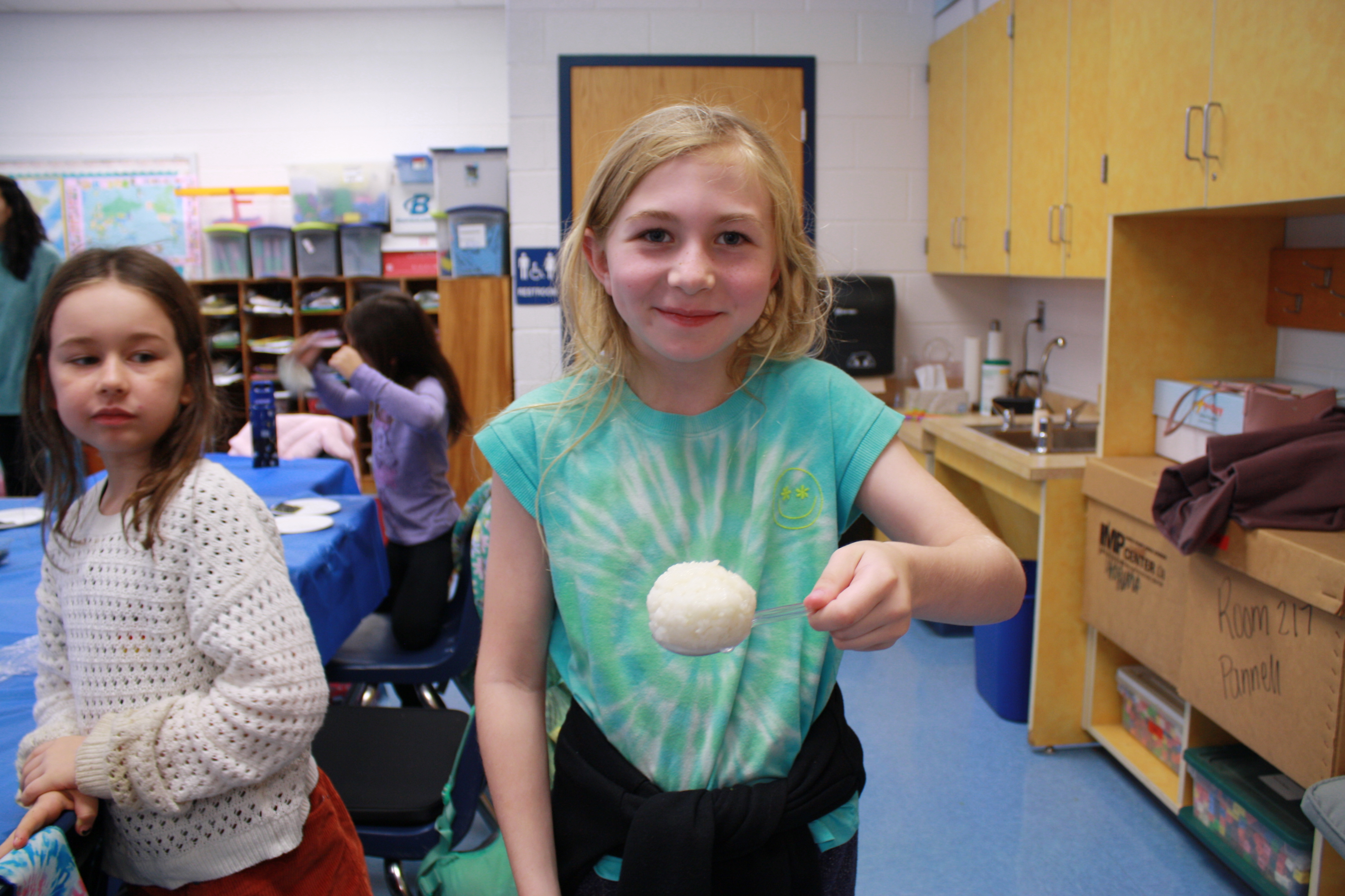 A student holds a rice ball she made