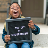 Student holds '1st day of kindergarten' sign